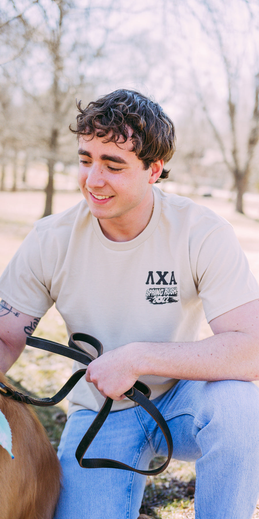 Boy wears a cream Lambda Chi Shirt with the LXA letters on the left.